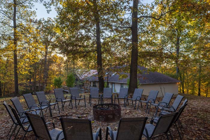 Fire pit gathering area with Peach Tree Lodge lit in the background