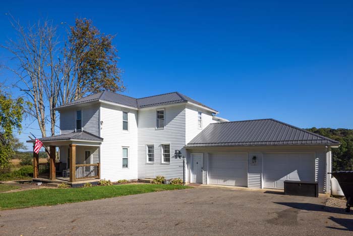 Ruby's Farmhouse exterior with two-car garage on a sunny day