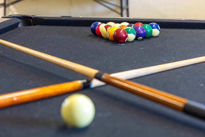 Pool table with racked balls and cues