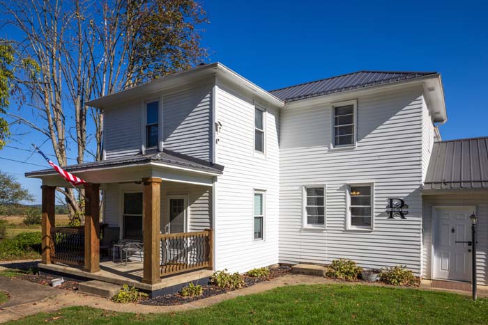 Front exterior of Ruby's Farmhouse with covered porch and American flag