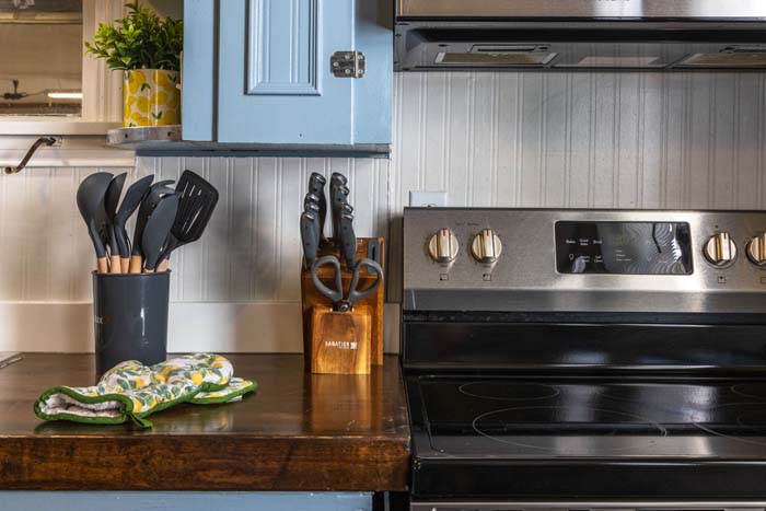 Kitchen with black electric range and utensils