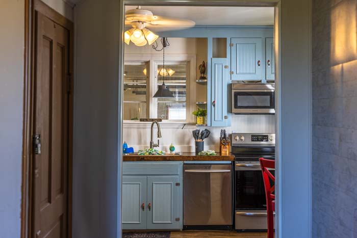 View into the blue farmhouse kitchen from the hallway
