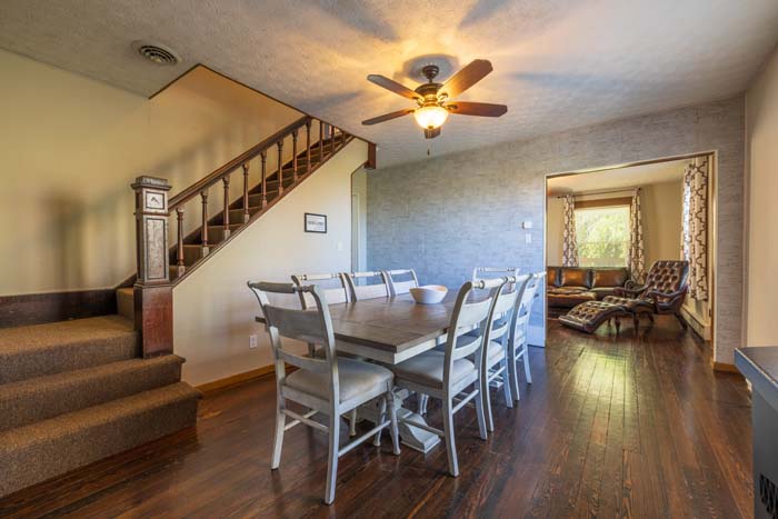 Dining area with farmhouse table and staircase