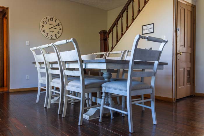 Gray-and-white dining set with wall clock and staircase