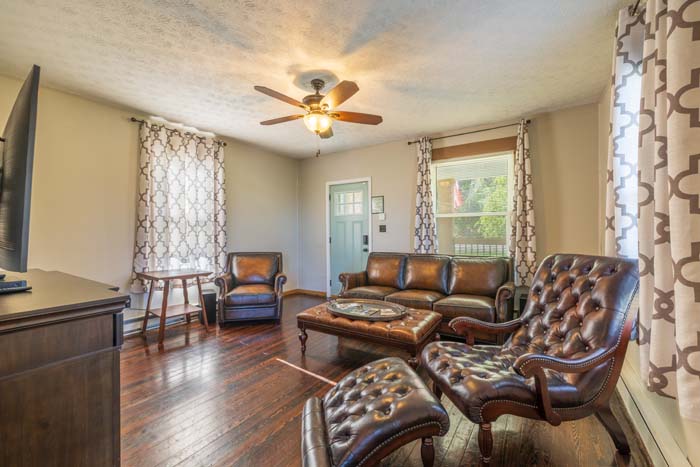 Living room with brown leather furniture and TV