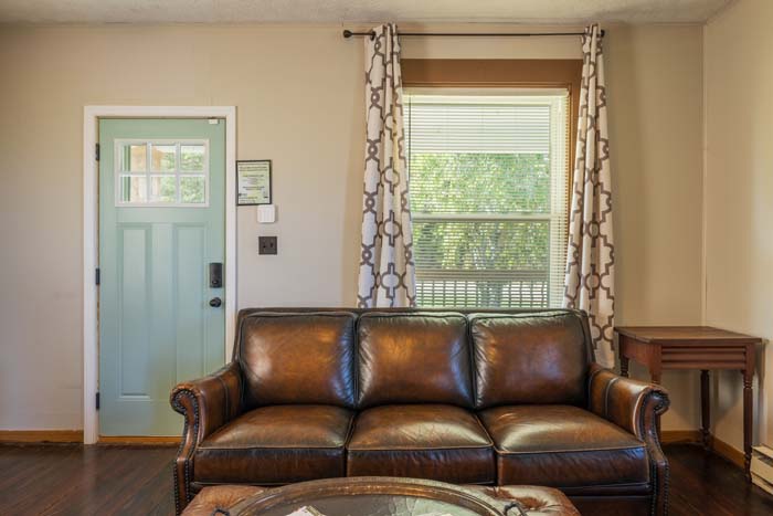 Living room with leather sofa and teal front door