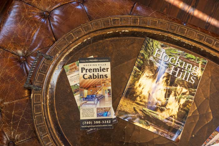 Hocking Hills Premier Cabins brochures on a leather ottoman
