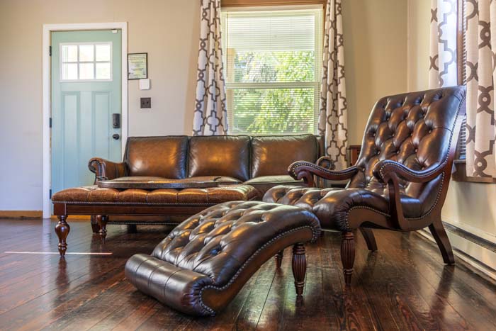 Living room with tufted leather chaise and chair