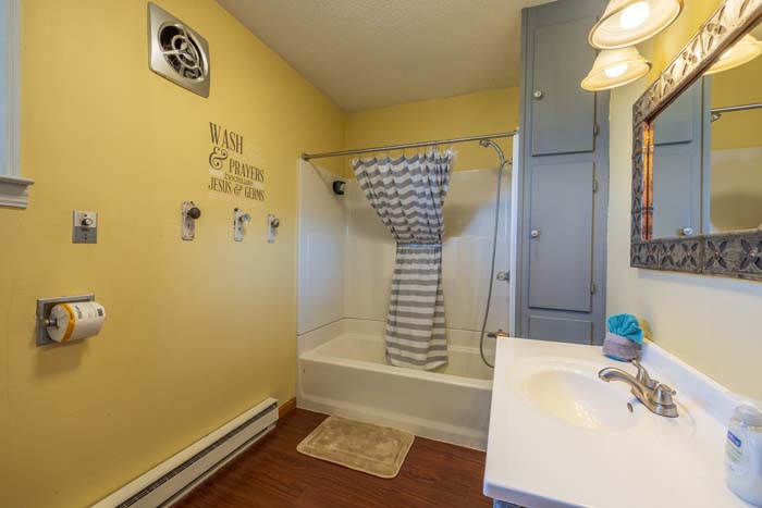 Bathroom with tub-shower and yellow walls