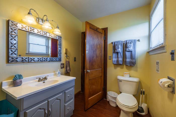 Bathroom vanity with decorative mirror and toilet