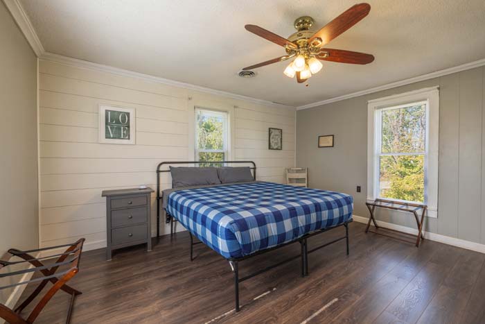 Bedroom with blue plaid bed and shiplap accent wall