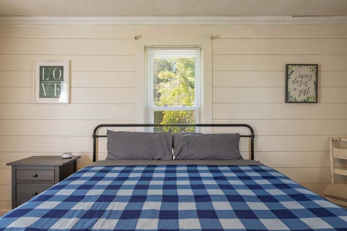 Bedroom with blue buffalo-check bedding and wall art