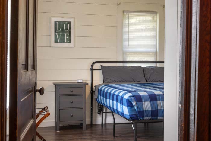 Bedroom with blue plaid bed viewed from the doorway