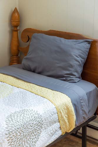 Twin bed with gray and yellow bedding