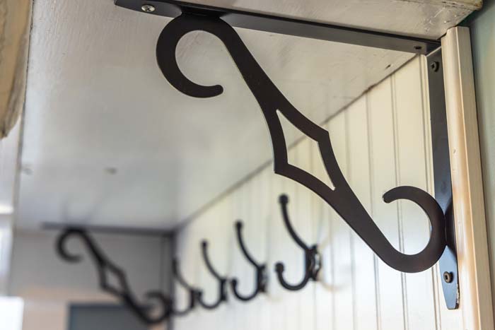 Decorative wrought-iron shelf bracket and coat hooks