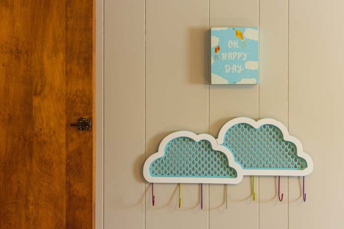 Kids' room with cloud coat hooks and Oh Happy Day art