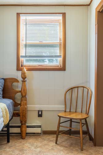 Bedroom with spindle bed and window seating