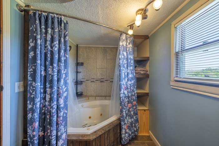 Corner jacuzzi tub with floral curtains