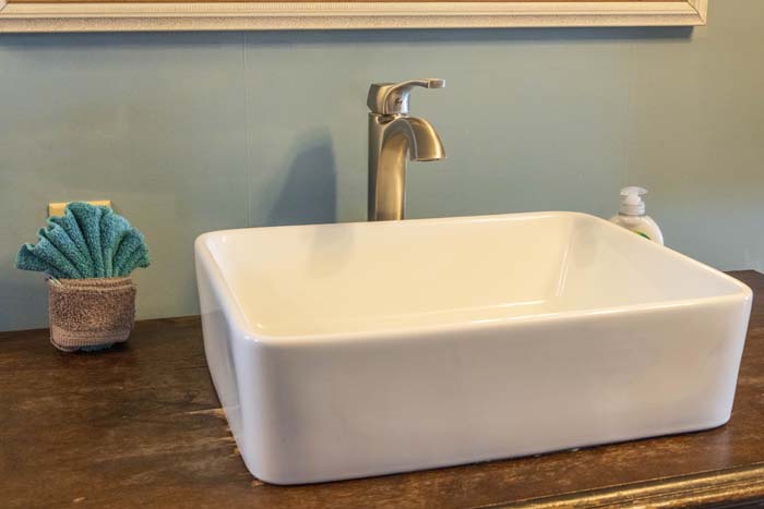 White vessel sink on a wood vanity