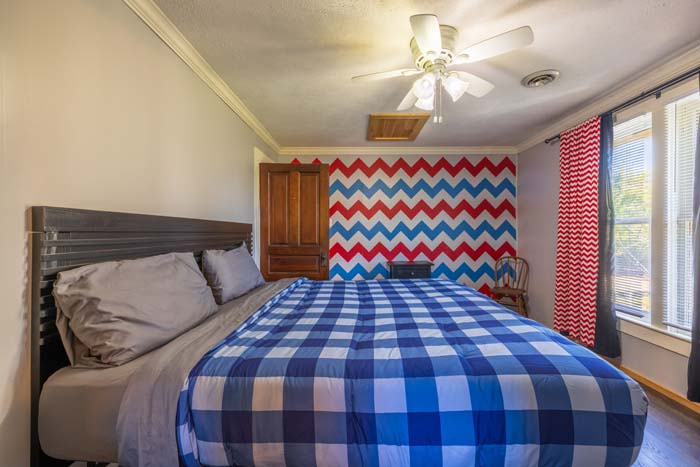 Bedroom with red, white, and blue chevron accent wall