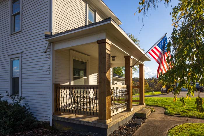 Covered front porch with flag and seating