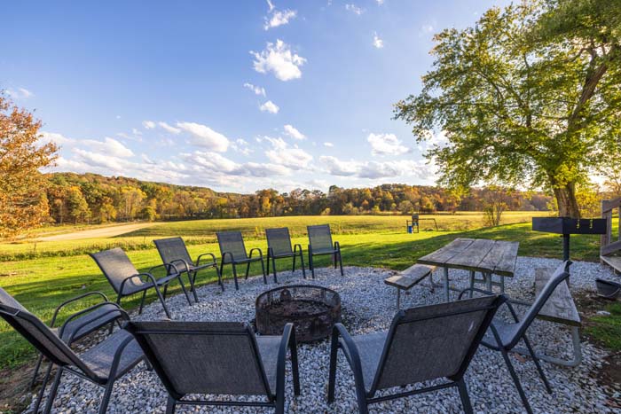 Outdoor fire pit with chairs overlooking the field