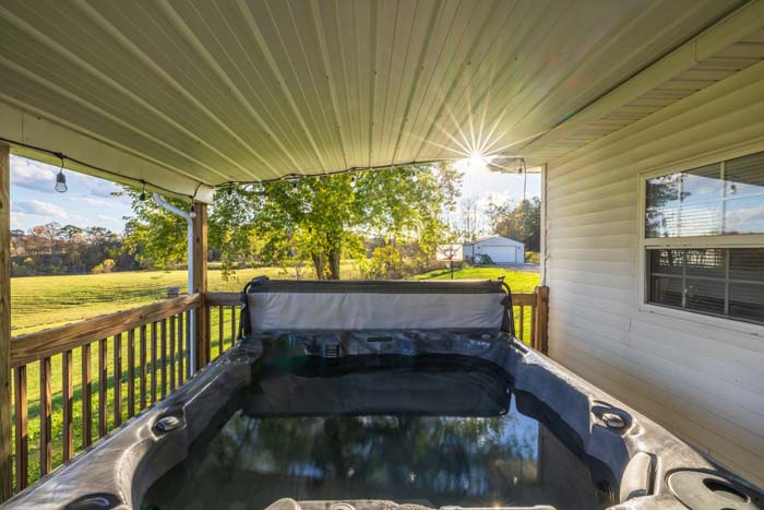 Hot tub on the covered deck at Ruby's Farmhouse