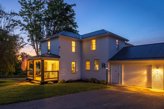 Exterior with garage lit at twilight