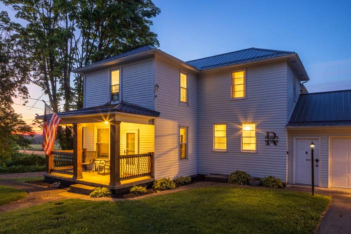 Front porch of Ruby's Farmhouse glowing at dusk