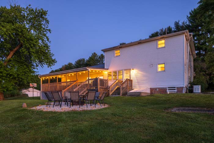 Rear covered deck with patio set at twilight