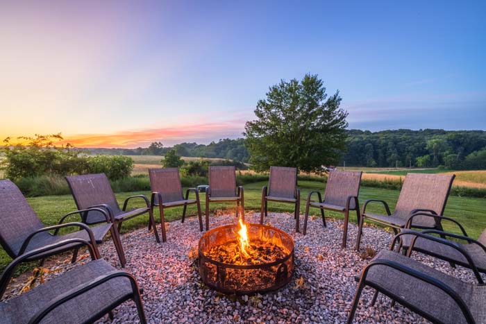 Fire pit glowing at dusk over the field