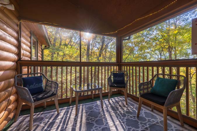 Screened porch overlooking woods at Bluebird Cabin