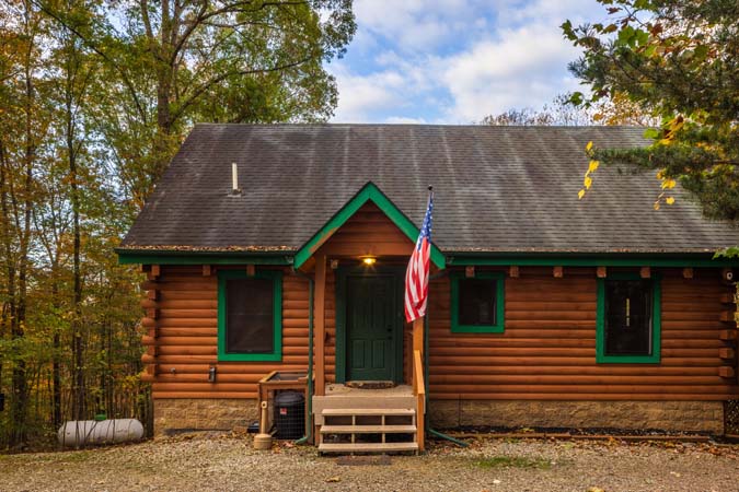 Outdoor hot tub area surrounded by trees at Catbird Cabin