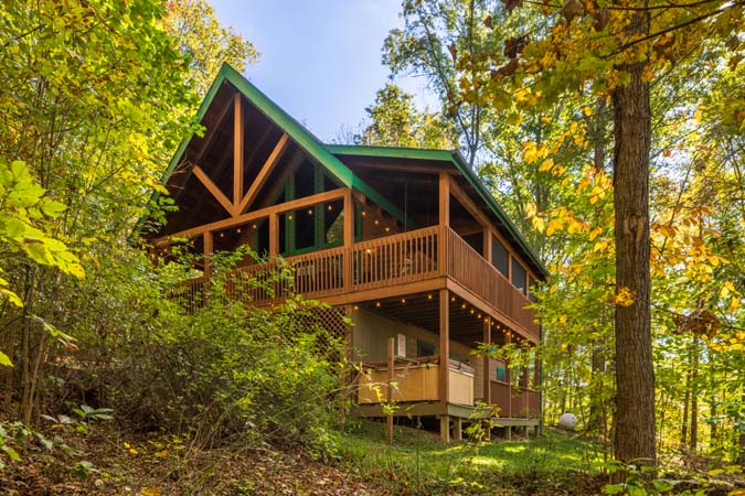Wraparound porch overlooking woods at Catbird Cabin