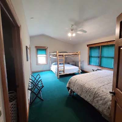 room with bunk beds and bed, green carpet